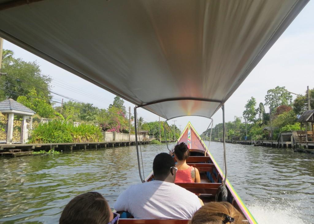 a u n e student rides a longboat in thailand