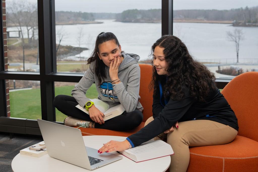 Two U N E students study together in the Ripich Commons