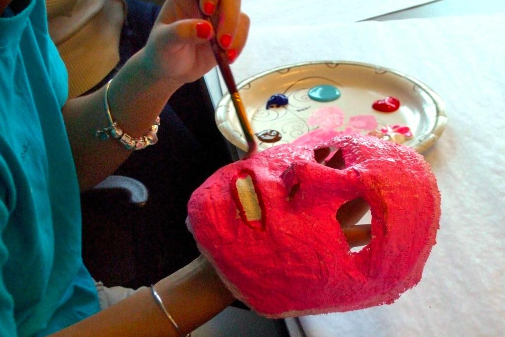 A student painting a mask