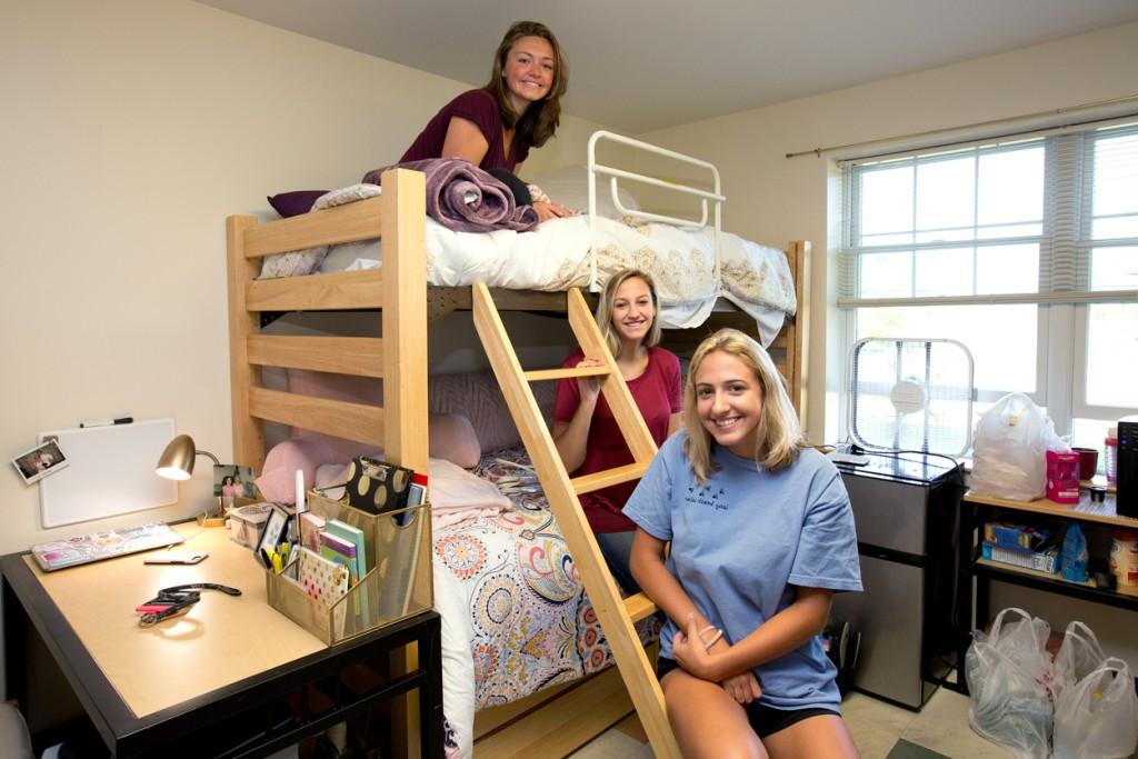 Three freshman hanging out in their new dorm room together