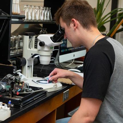 一个学生在看显微镜