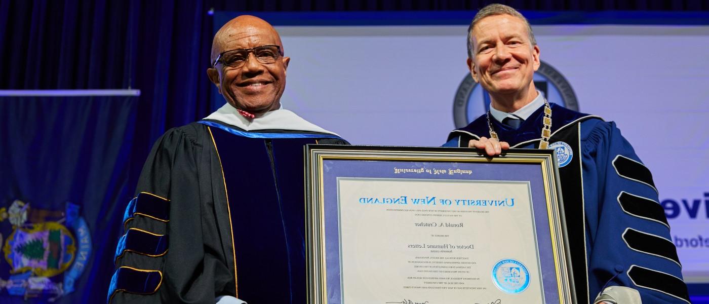 President Herbert presents an award at the 2023 U N E Commencement ceremony