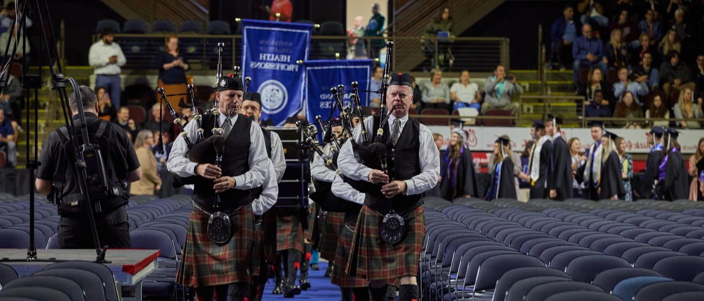 Bagpipers walk down the aisle at commencement