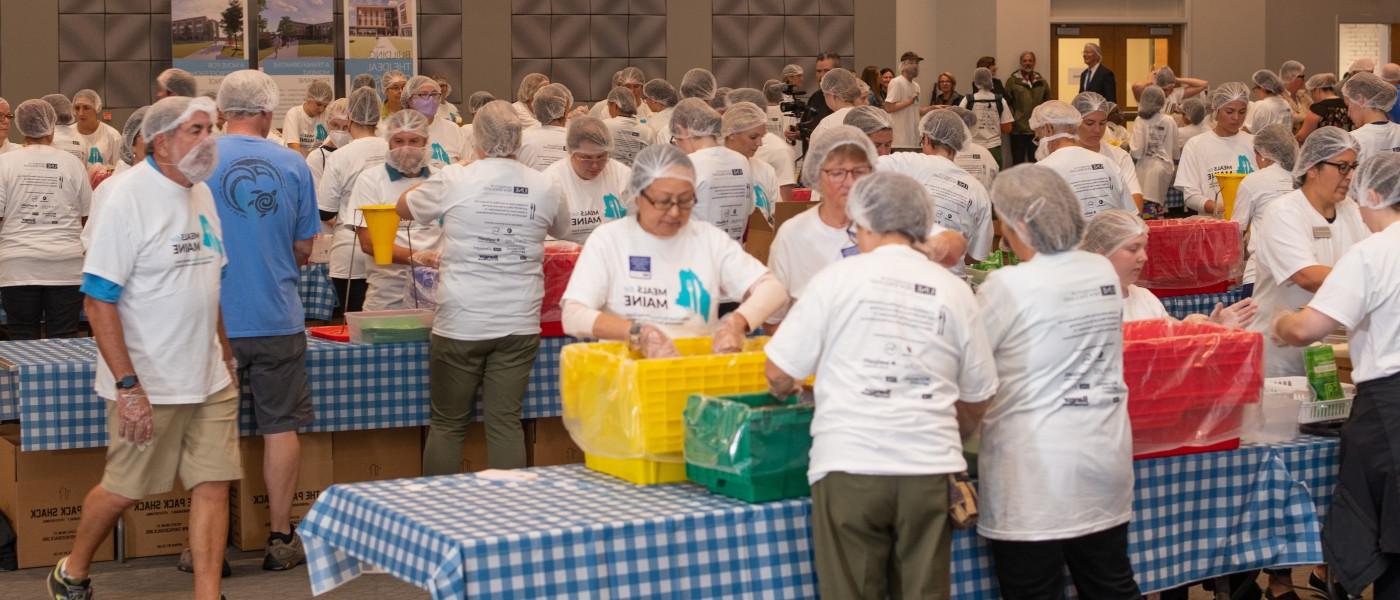 一间堆满饭菜的房间，供缅因州志愿者打包饭菜