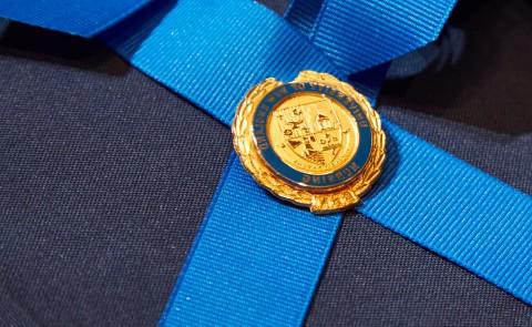 A nursing pin with the UNE crest