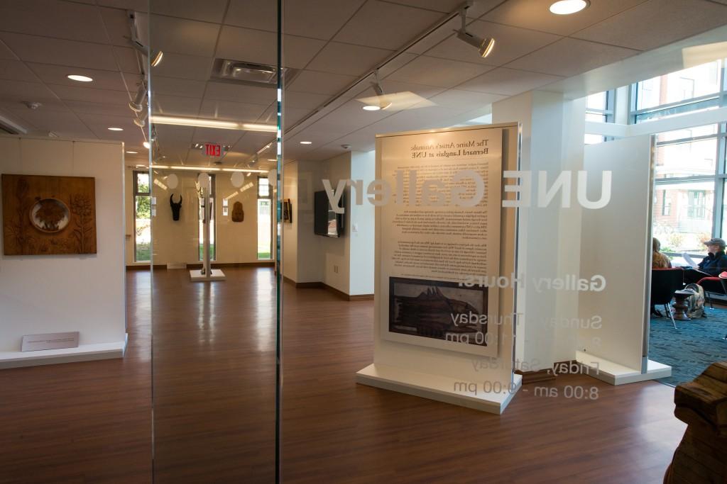 比德福德校区艺术画廊的内部照片，有一扇玻璃门上写着“U N E画廊”.挂在里面的艺术品可以透过门看到.